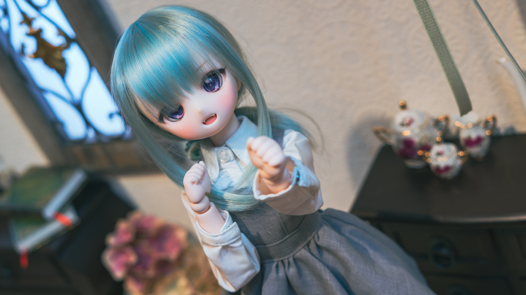 ブルーのウィッグを着けたドールが室内でポージングしている写真